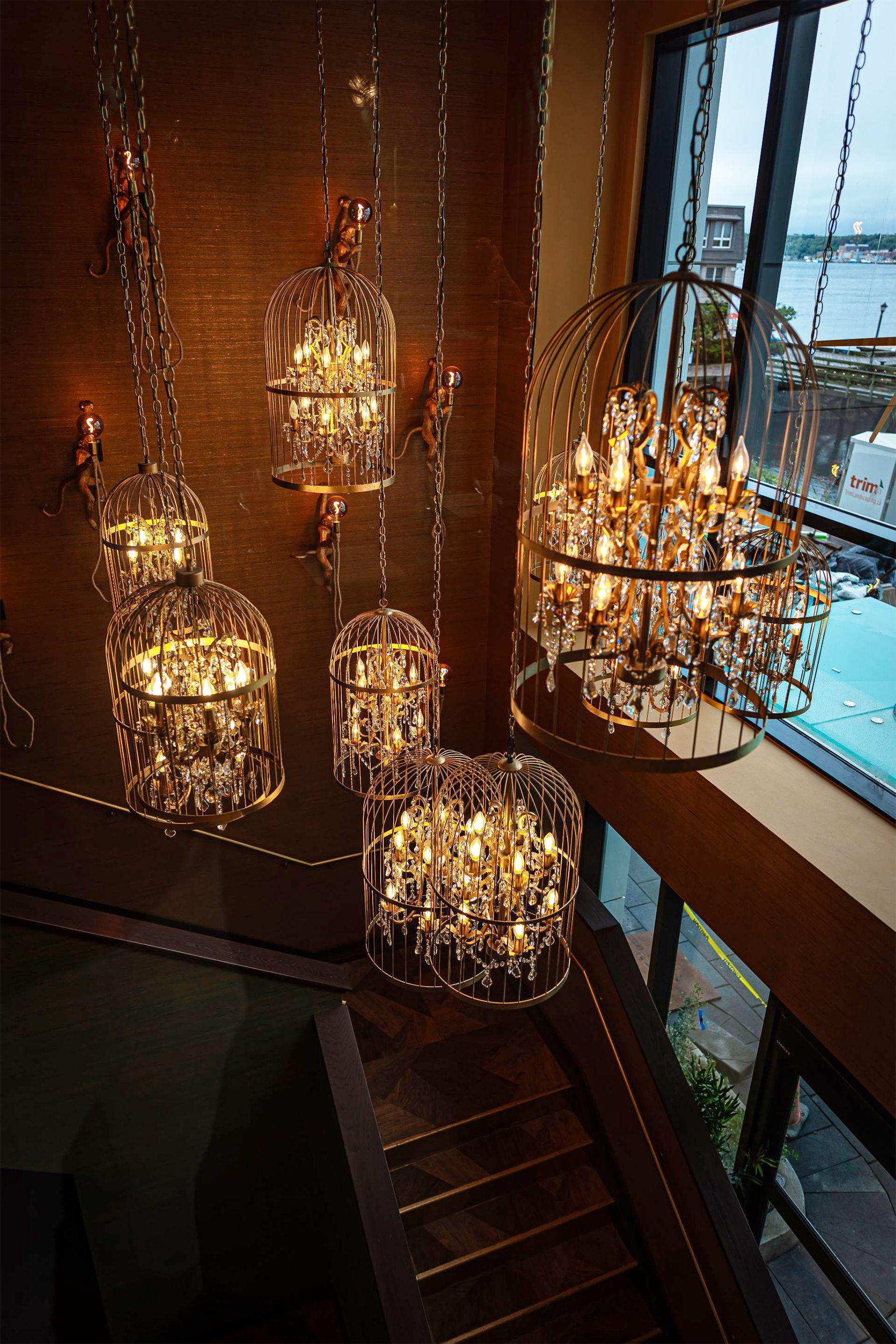Cage chandelier installed in a contemporary hospitality interior with industrial architectural styling.