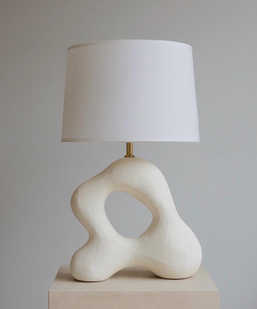 Front view of an organic table lamp highlighting flowing forms and refined craftsmanship.