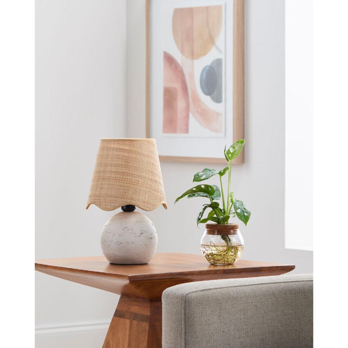 Organic table lamp placed on a wooden side table in a contemporary residential living room creating warm ambient lighting.