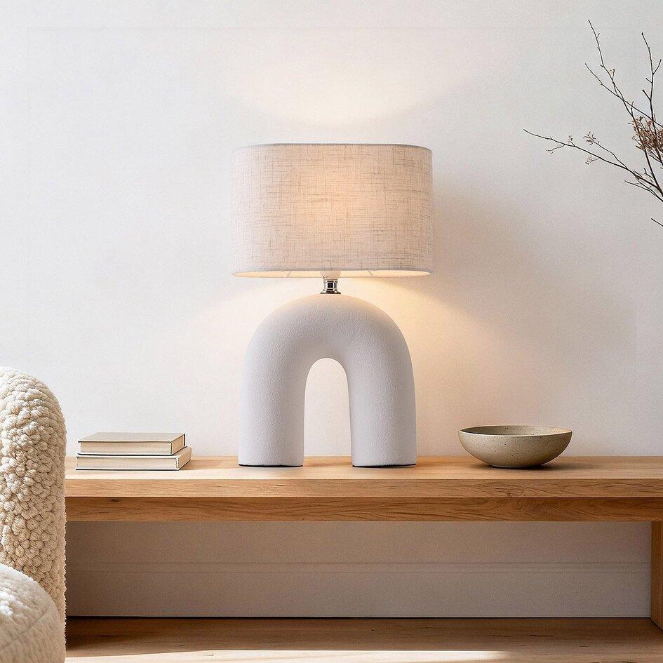 Organic table lamp placed on a wooden side table in a contemporary residential living room creating warm ambient lighting.