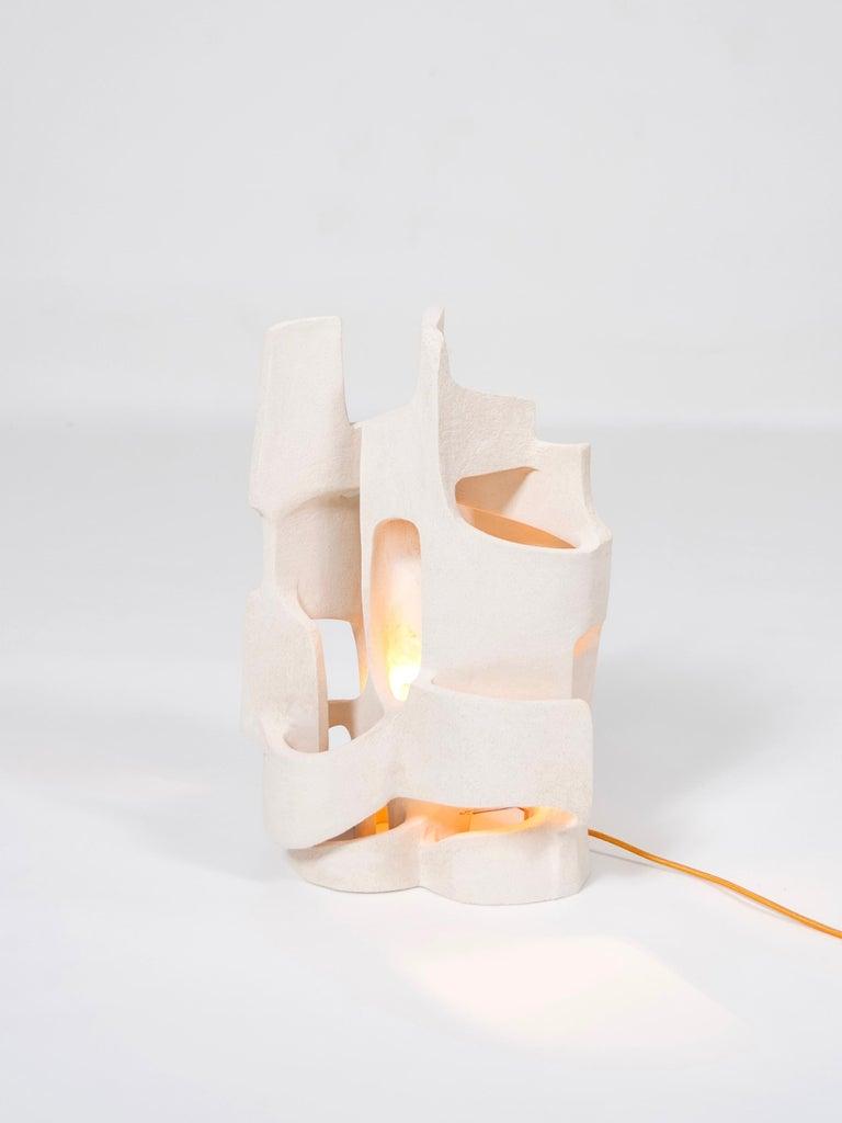 Front view of a sculptural table lamp showcasing expressive geometry and refined architectural detailing.