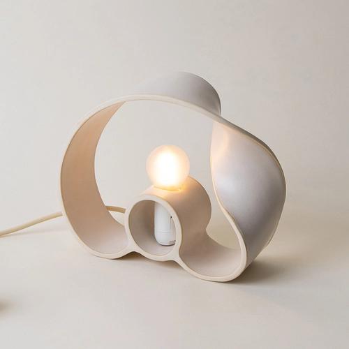 Front view of a sculptural table lamp showcasing expressive geometry and refined architectural detailing.