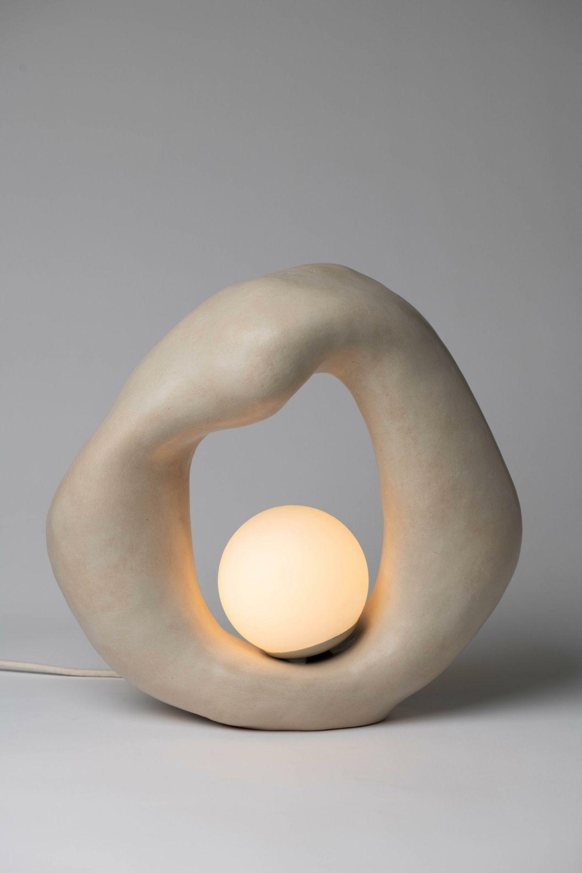 Front view of a sculptural table lamp showcasing expressive geometry and refined architectural detailing.