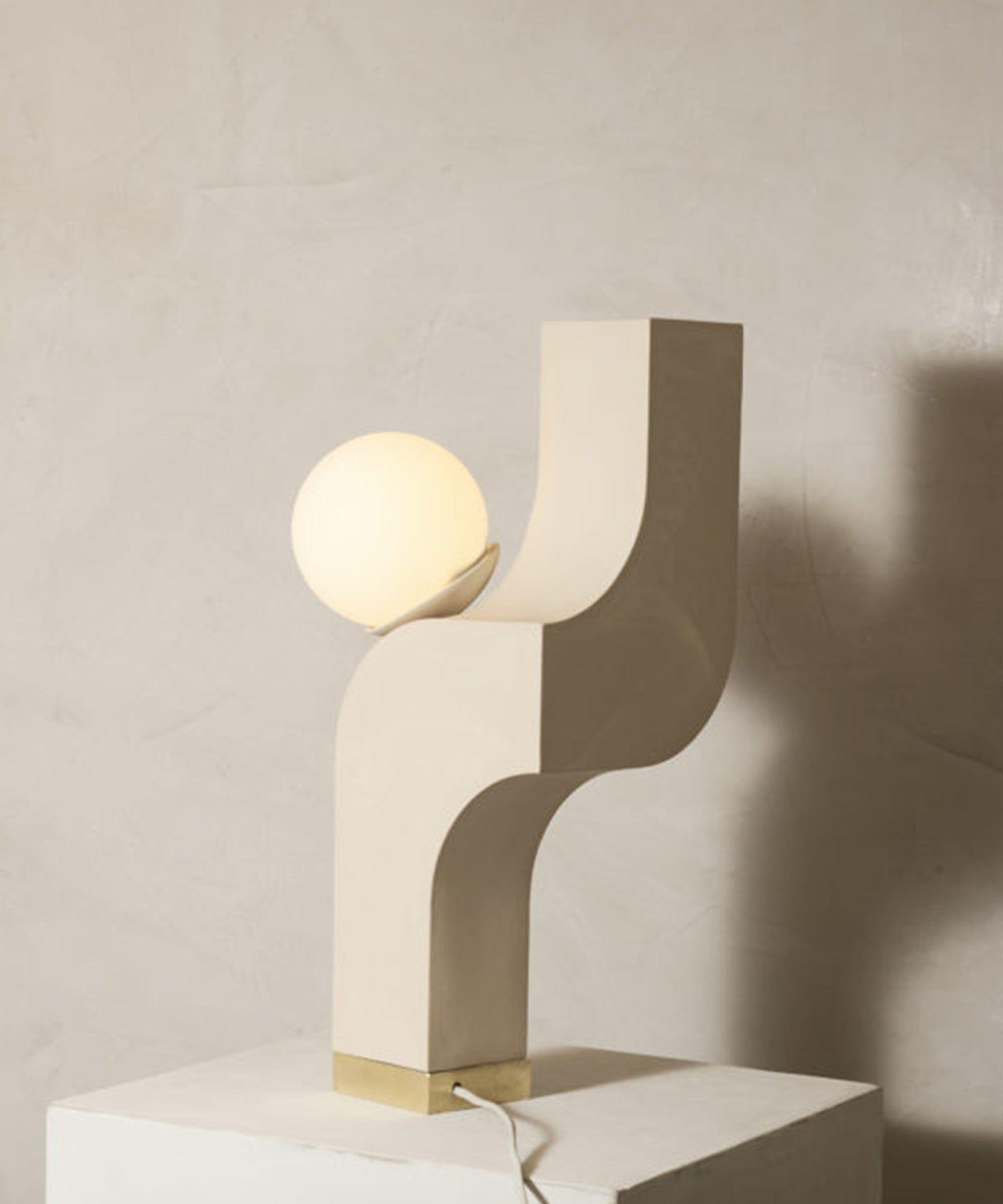 Front view of a sculptural table lamp showcasing expressive geometry and refined architectural detailing.