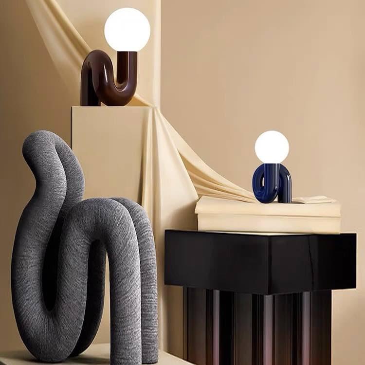 Sculptural table lamp displayed in a luxury hotel lobby creating an artistic focal point with elegant ambient lighting.