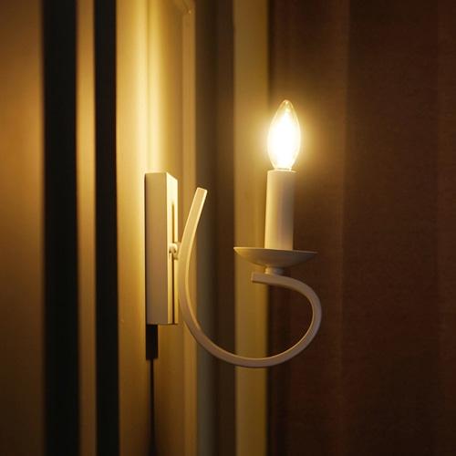 Candle wall lamp installed in a luxury hospitality interior with timeless architectural detailing.