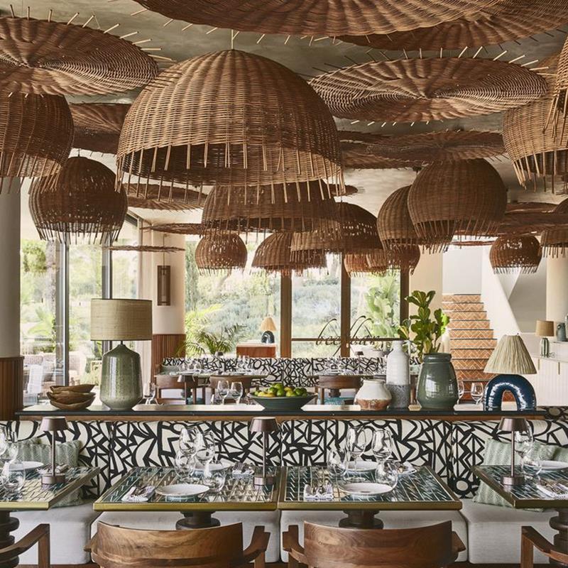 Woven chandelier installed in a luxury resort restaurant with contemporary natural architecture.