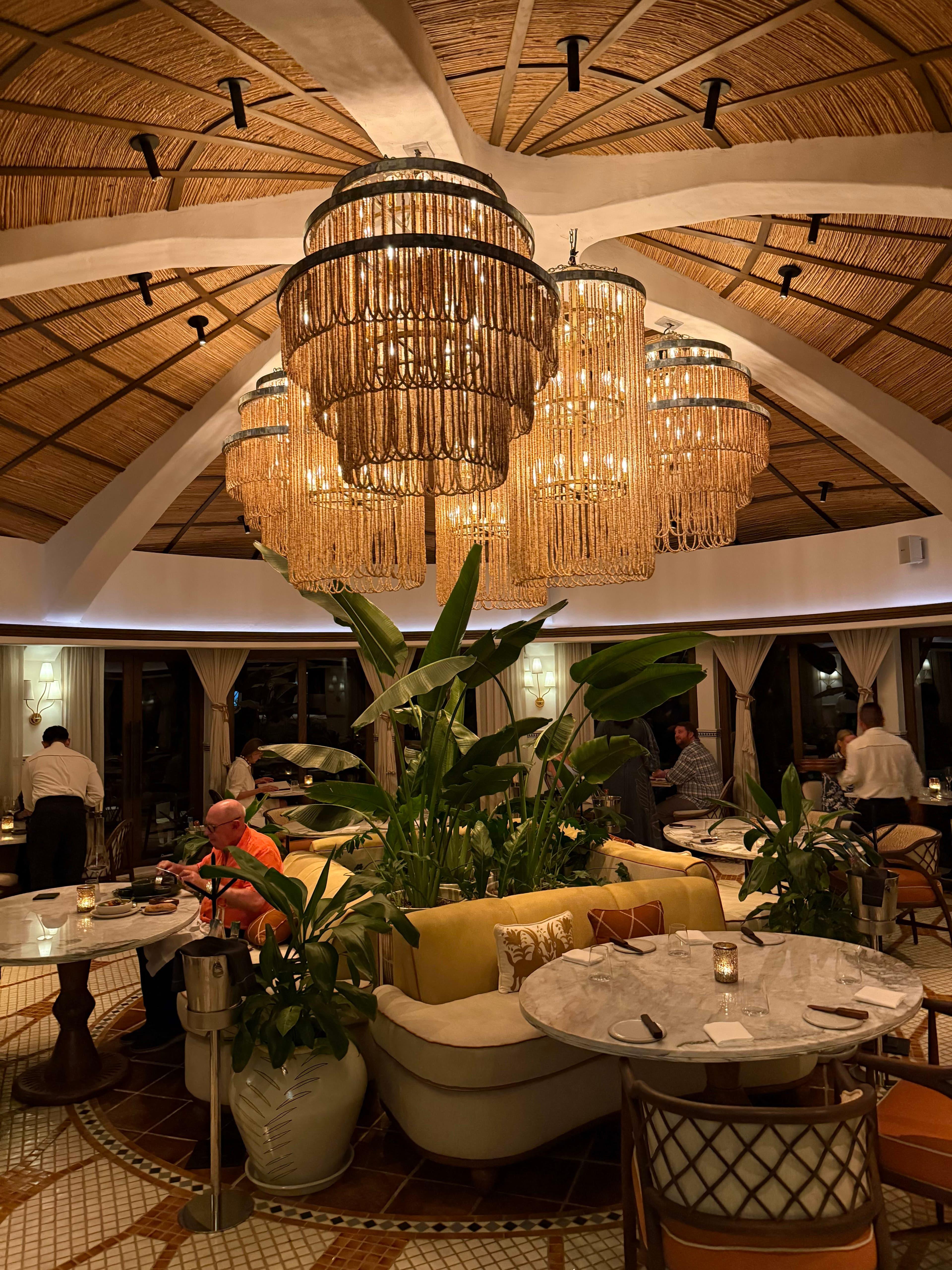 Woven chandelier installed in a luxury resort restaurant with contemporary natural architecture.