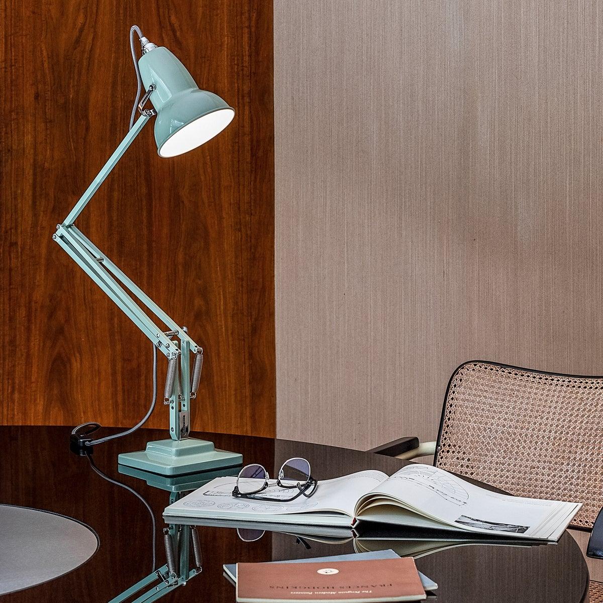 Reading table lamp positioned beside a bed in a luxury hotel guest room providing comfortable focused illumination for reading.