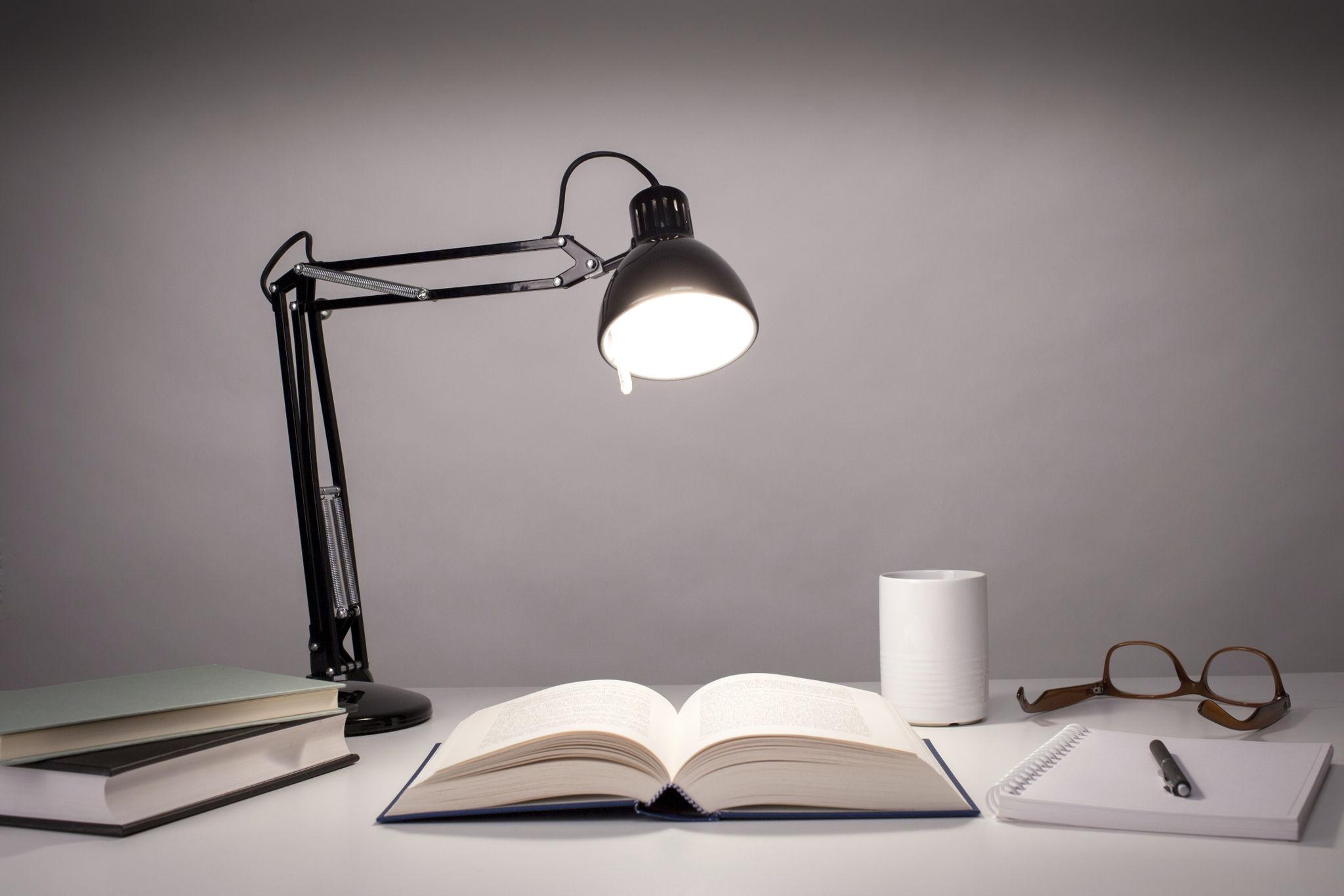 Reading table lamp positioned beside a bed in a luxury hotel guest room providing comfortable focused illumination for reading.