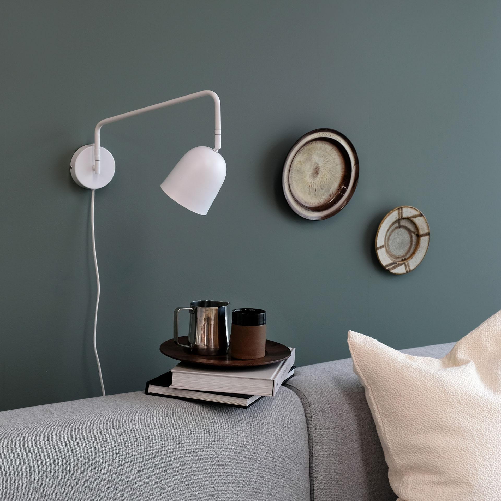 Scandinavian wall lamp installed in a minimalist residential interior with warm natural finishes.