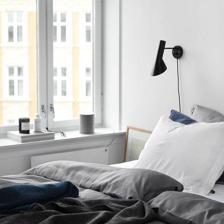 Scandinavian wall lamp installed in a minimalist residential interior with warm natural finishes.
