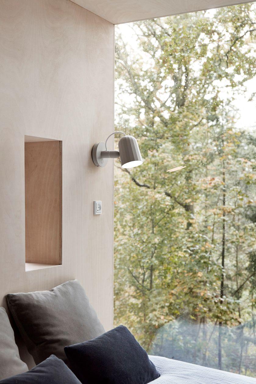 Scandinavian wall lamp installed in a minimalist residential interior with warm natural finishes.