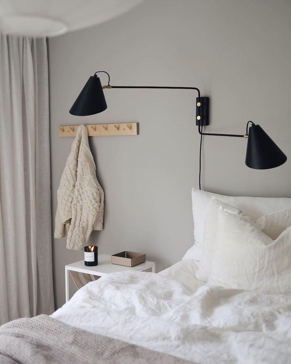 Scandinavian wall lamp installed in a minimalist residential interior with warm natural finishes.