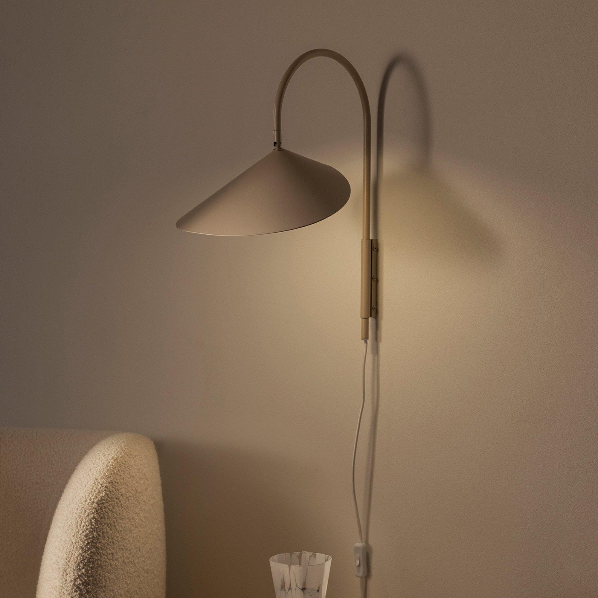 Scandinavian wall lamp installed in a minimalist residential interior with warm natural finishes.