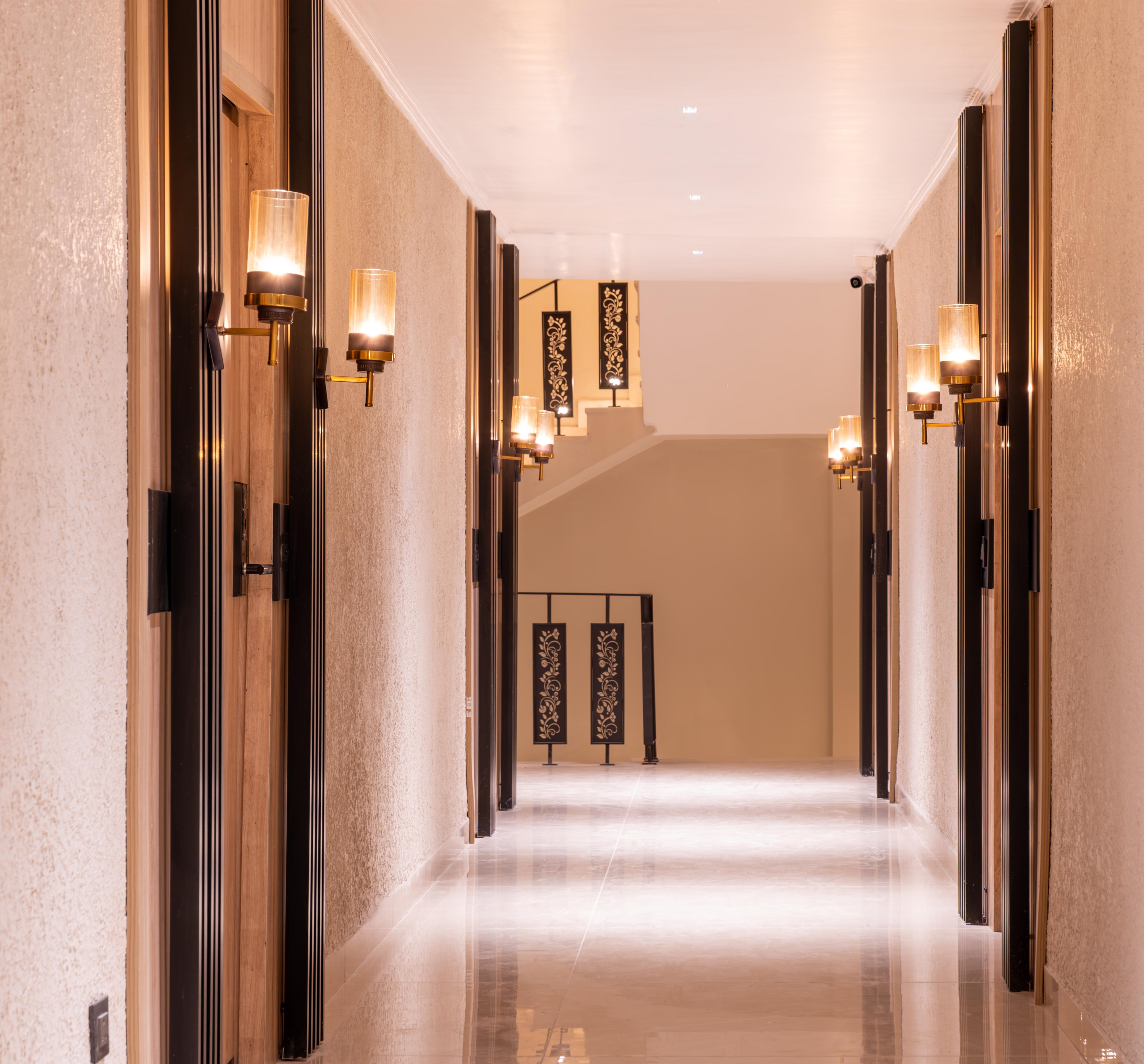 Contemporary wall lamp installed in a luxury hotel interior with sophisticated architectural styling.