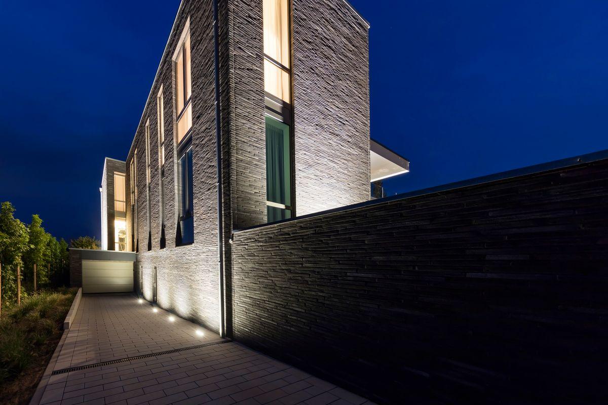 Wall grazing inground lights highlighting a contemporary building façade.