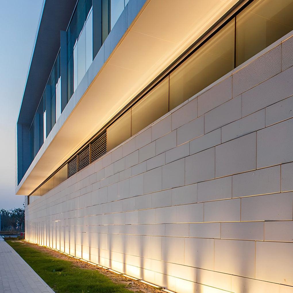 Wall grazing inground lights highlighting a contemporary building façade.