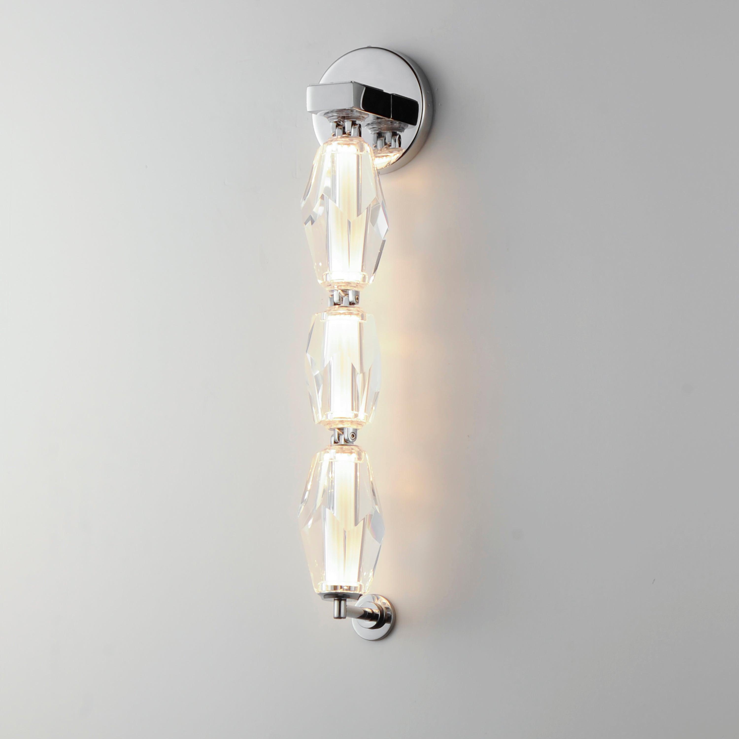 Front view of a luxury crystal wall lamp with elegant decorative detailing.