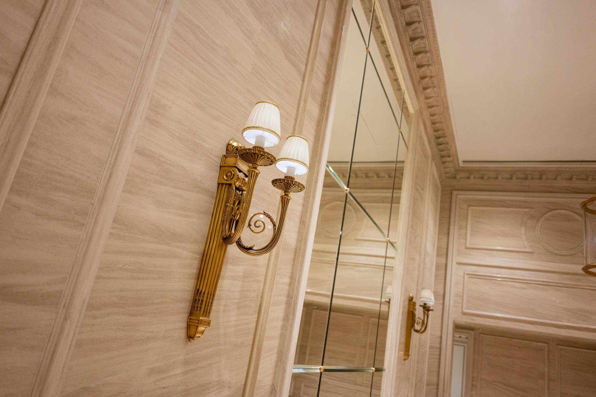 Classic wall lamp installed in a luxury heritage hotel with classical architectural interiors.