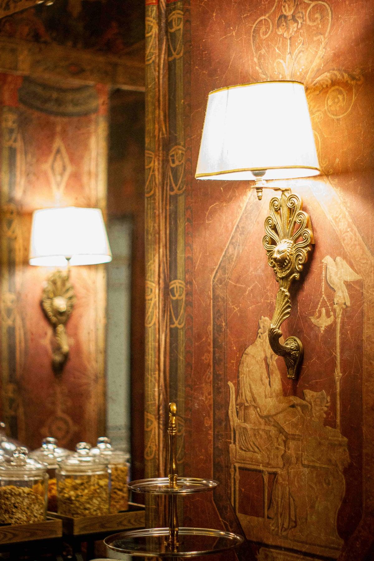 Classic wall lamp installed in a luxury heritage hotel with classical architectural interiors.
