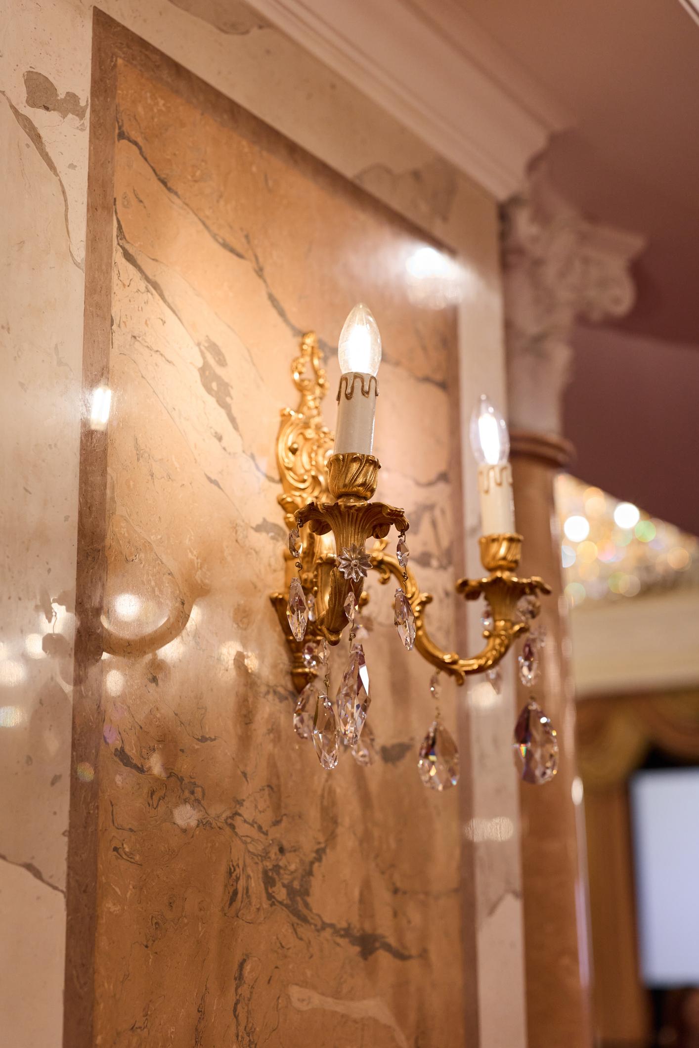 Classic wall lamp installed in a luxury heritage hotel with classical architectural interiors.