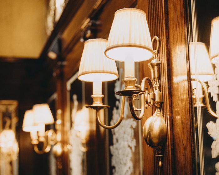 Classic wall lamp installed in a luxury heritage hotel with classical architectural interiors.
