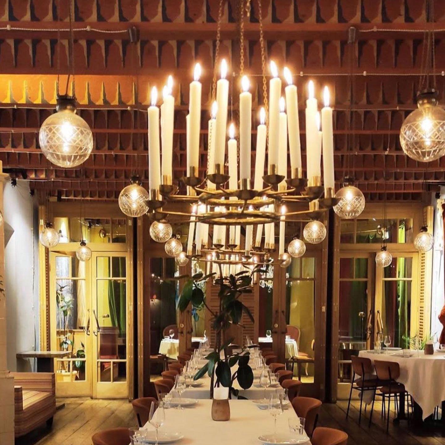 Candle chandelier installed in a luxury residential dining room with timeless architectural styling.