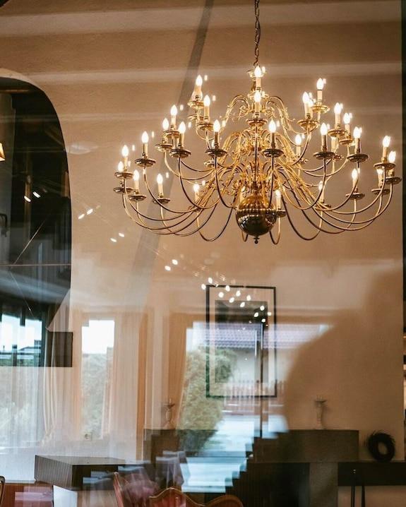 Candle chandelier installed in a luxury residential dining room with timeless architectural styling.