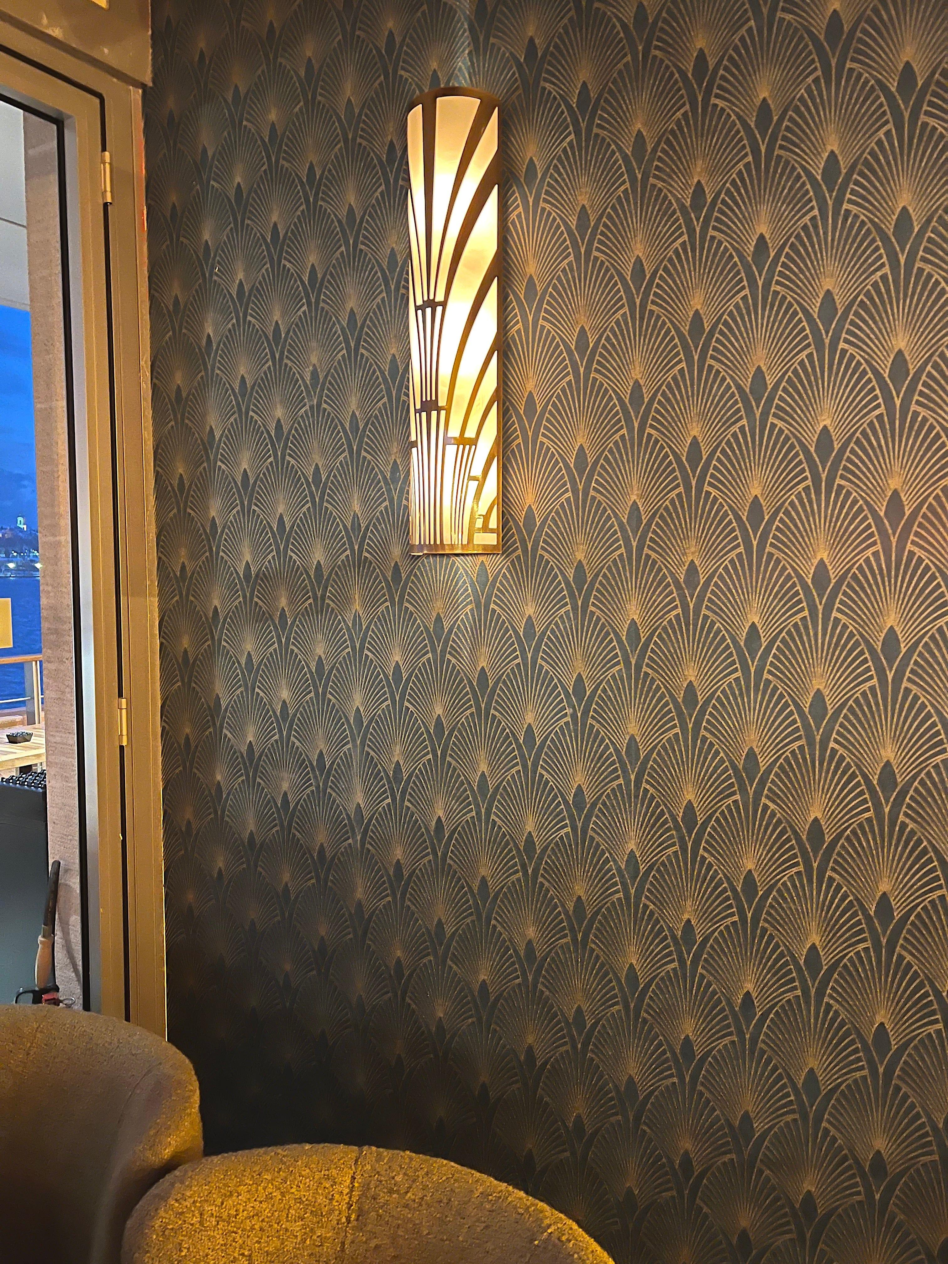 Art Deco wall lamp installed in a luxury boutique hotel with refined Art Deco architectural interiors.