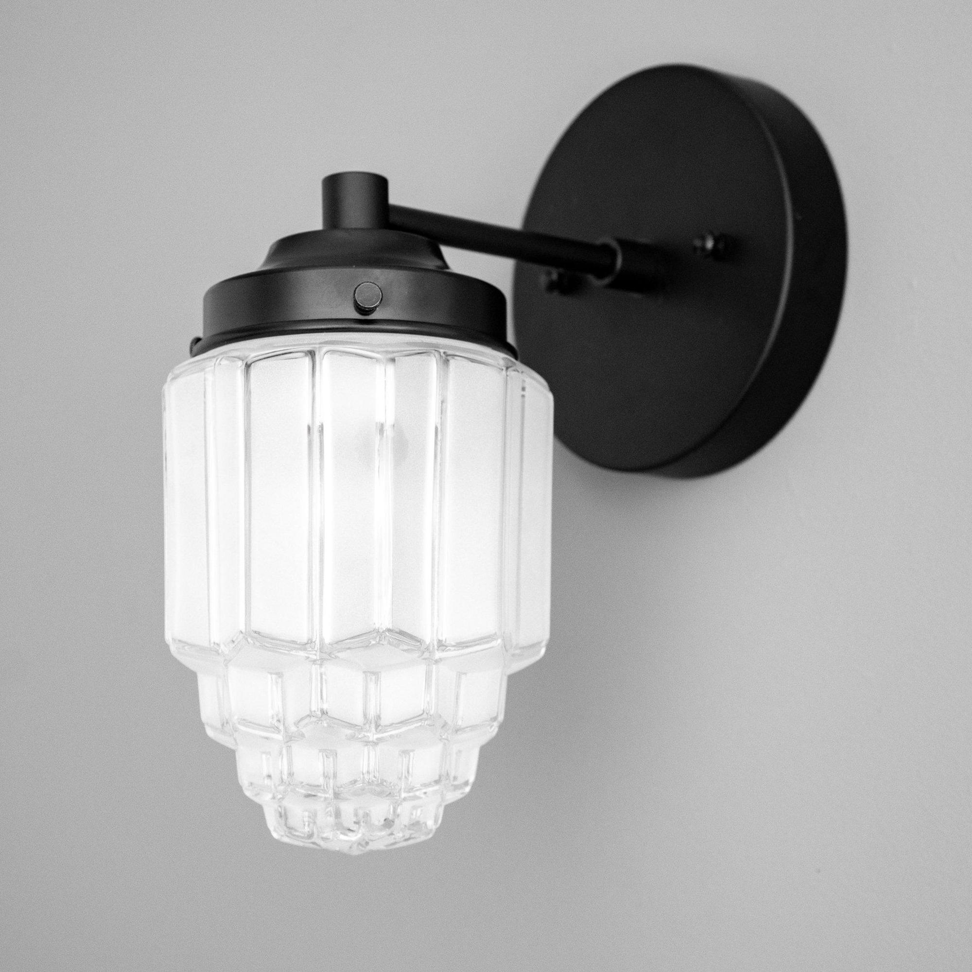 Front view of an Art Deco wall lamp with premium brass and decorative glass elements.