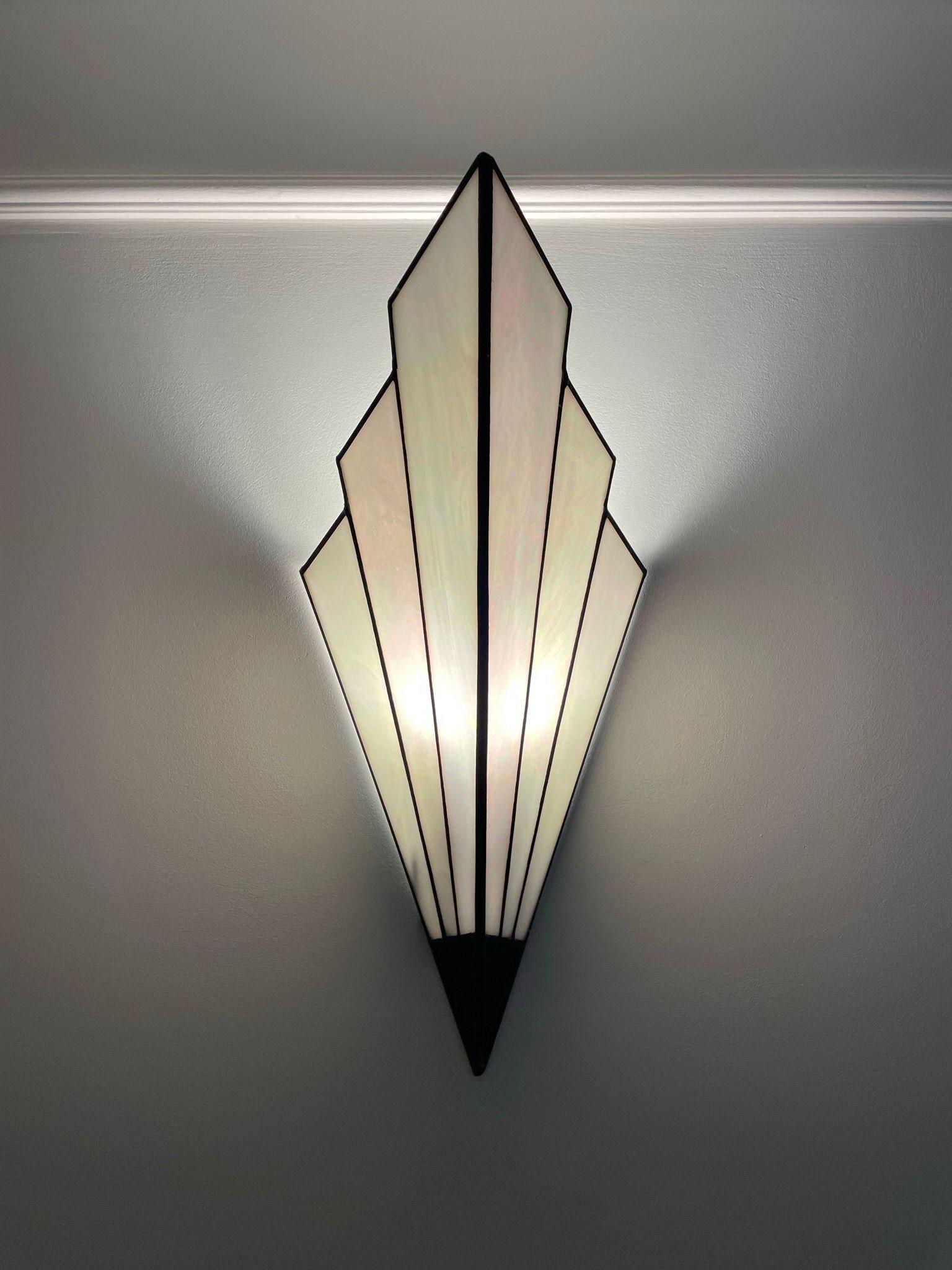 Front view of an Art Deco wall lamp with premium brass and decorative glass elements.
