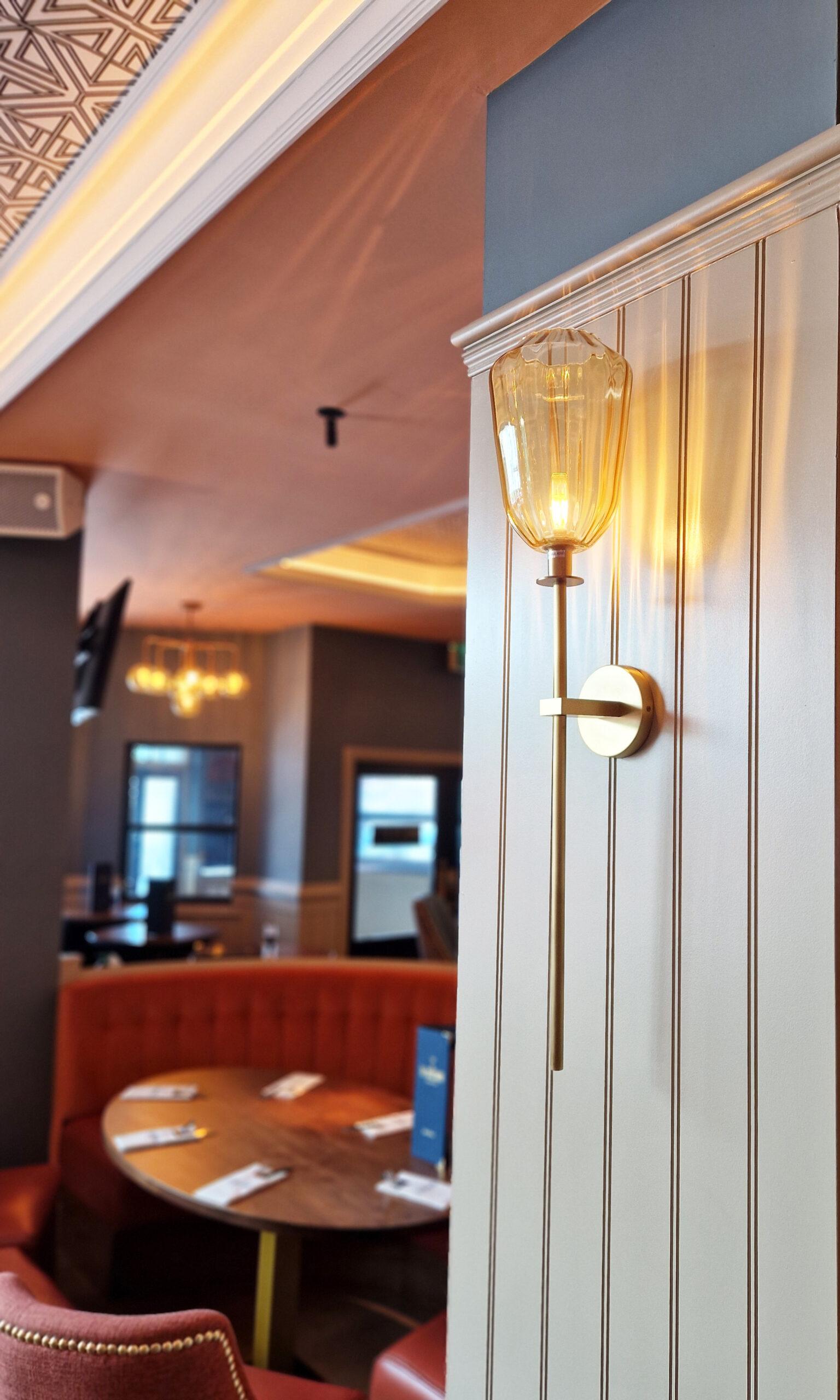 Art Deco wall lamp installed in a luxury boutique hotel with refined Art Deco architectural interiors.