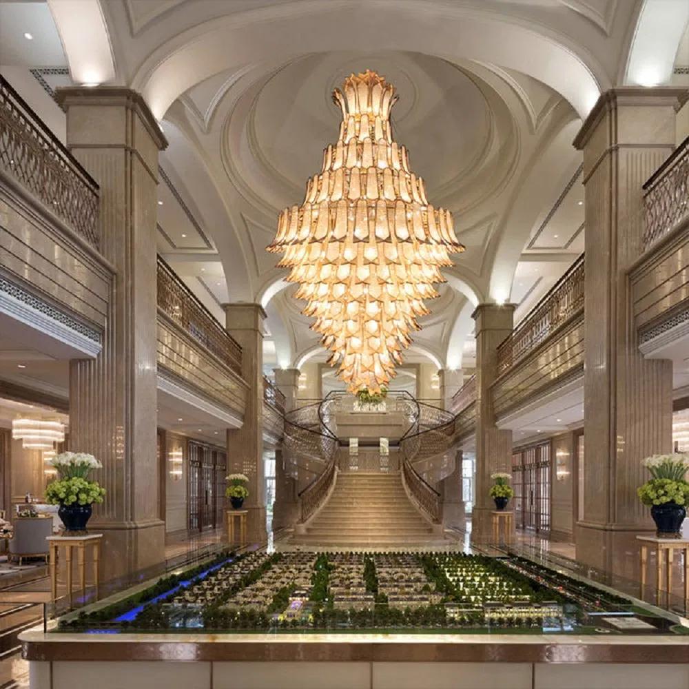 Tiered chandelier installed in a luxury hotel atrium with dramatic architectural lighting.
