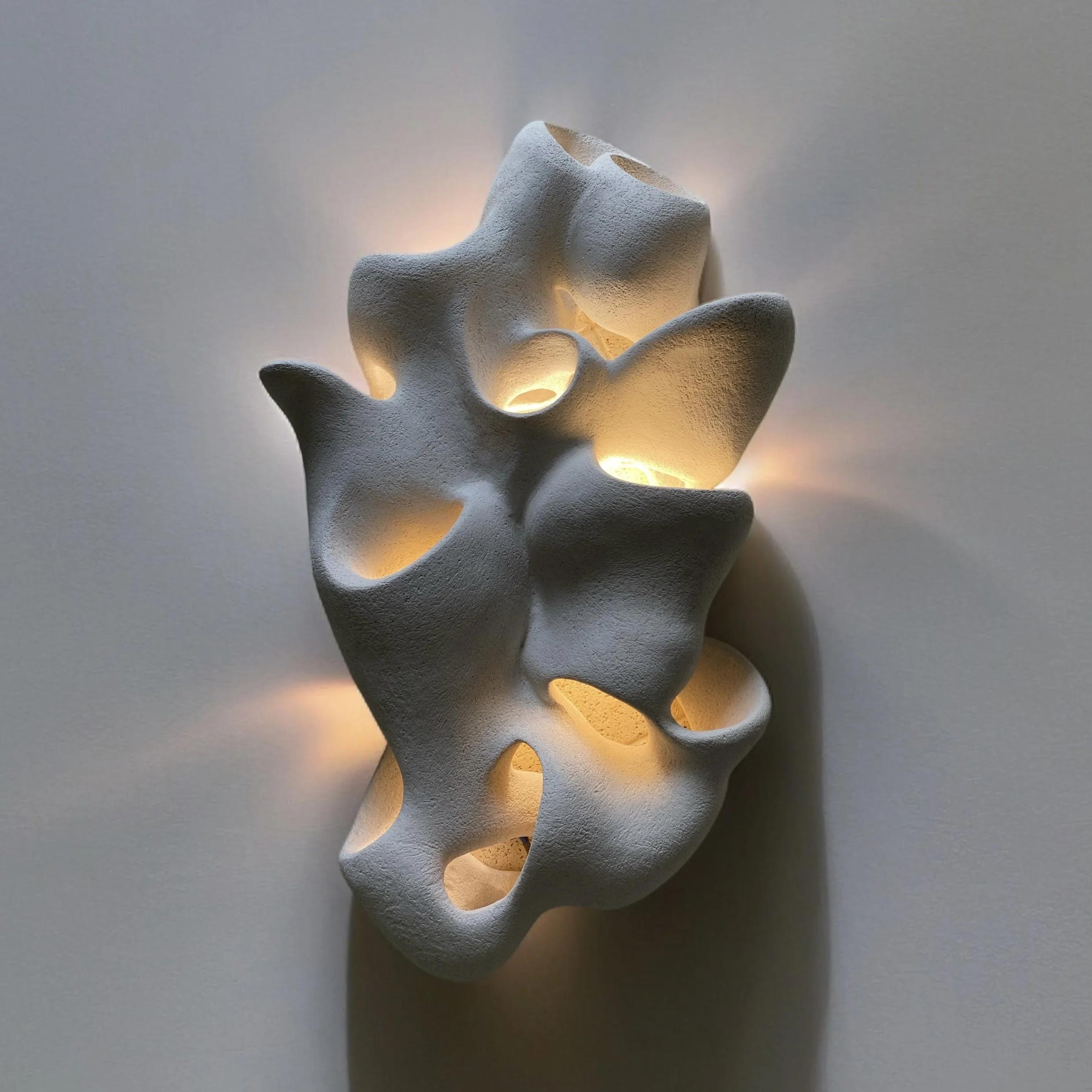 Front view of an organic wall lamp with soft curves and refined architectural detailing.