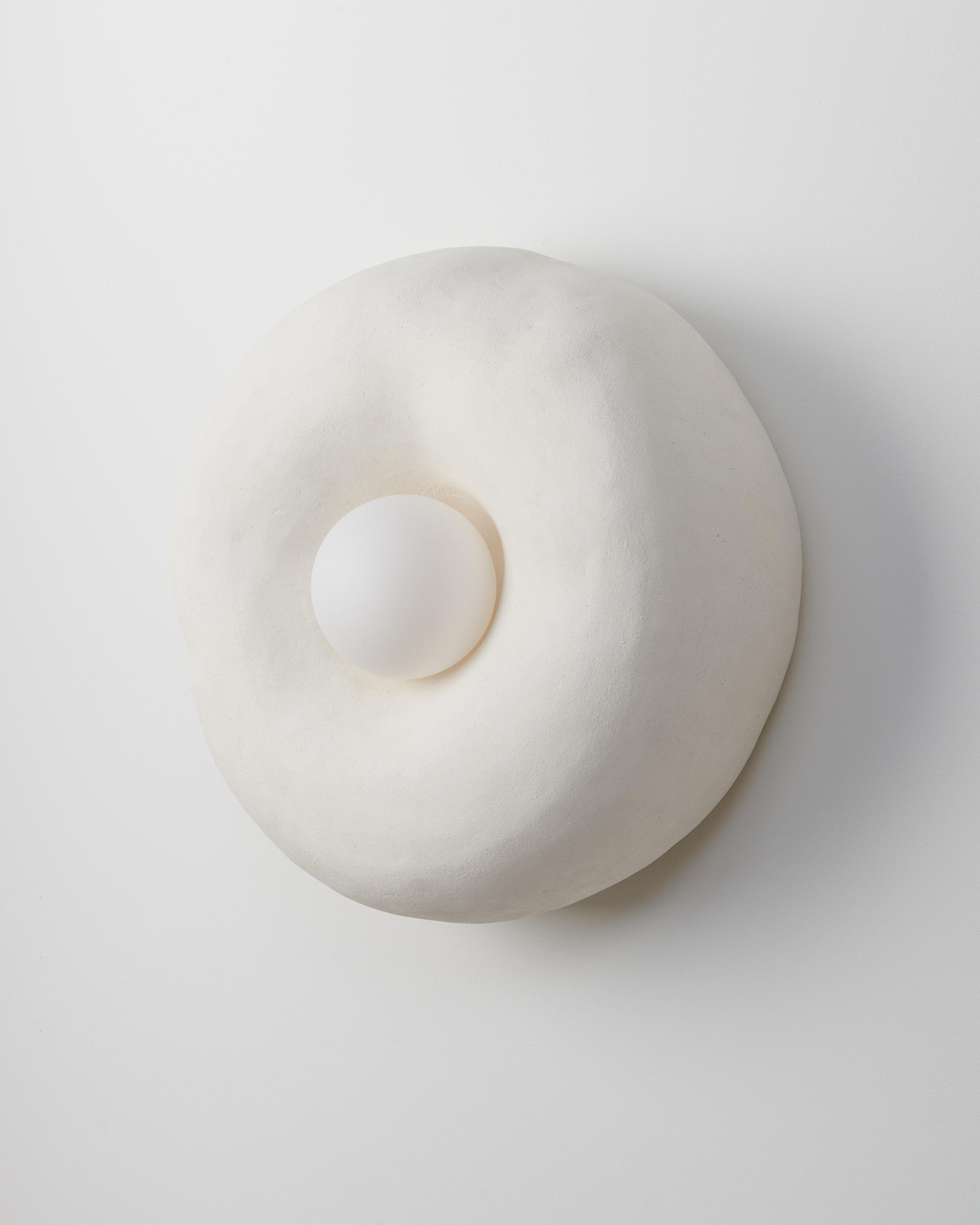 Front view of an organic wall lamp with soft curves and refined architectural detailing.