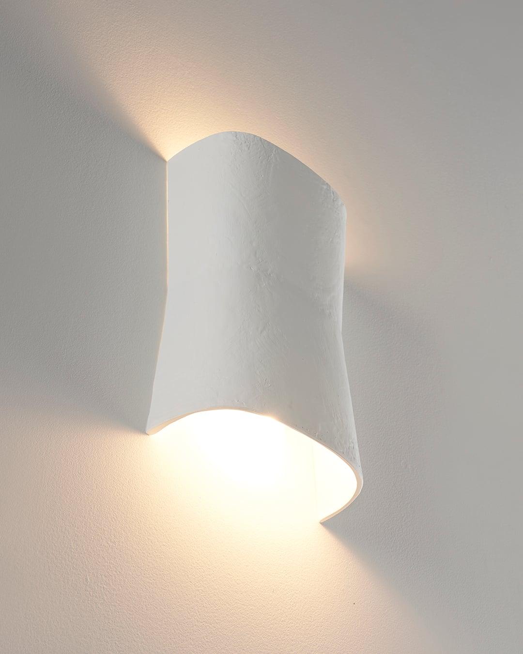 Front view of an organic wall lamp with soft curves and refined architectural detailing.