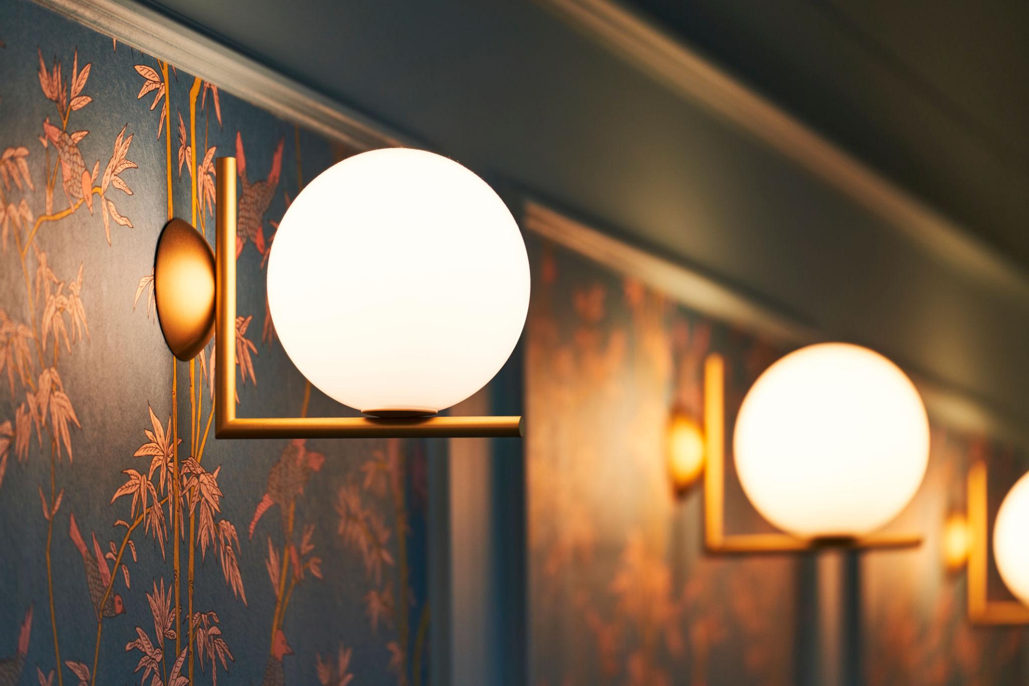 Globe wall lamp installed in a premium hospitality interior with contemporary architectural styling.
