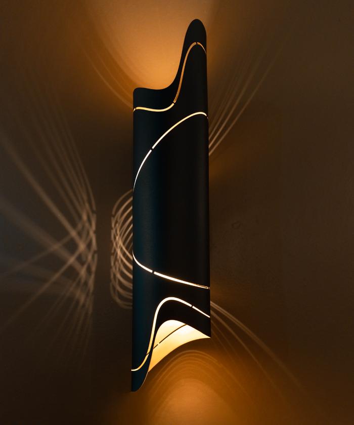 Front view of a sculptural wall lamp combining premium materials with contemporary design.