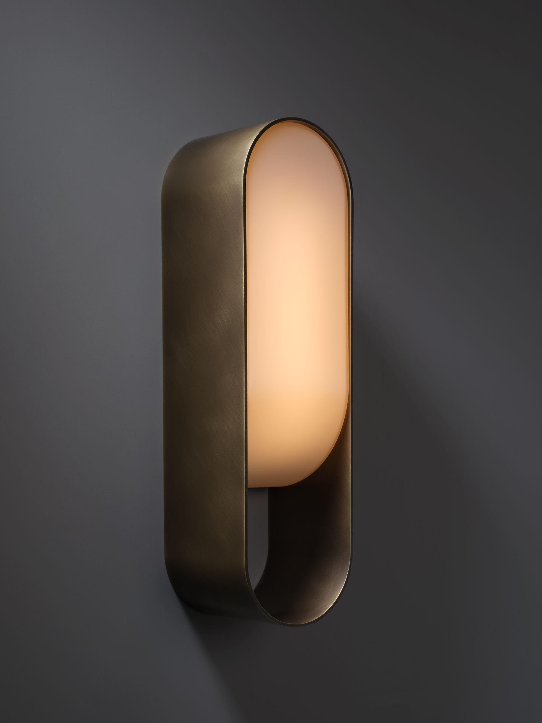 Front view of a sculptural wall lamp combining premium materials with contemporary design.