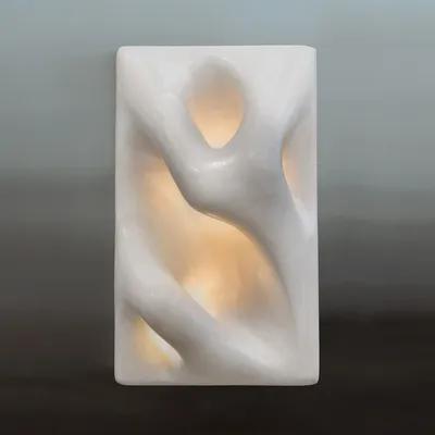 Front view of a sculptural wall lamp combining premium materials with contemporary design.