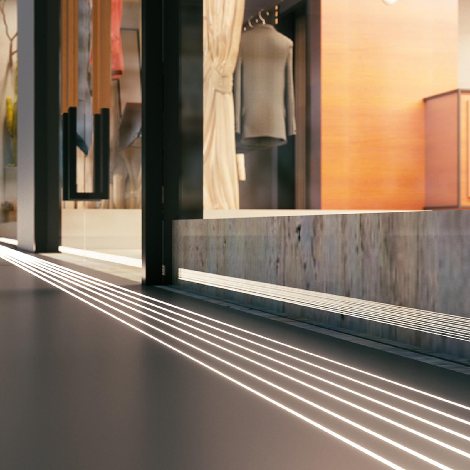 Floor LED profiles integrated into a contemporary retail showroom and public circulation area.