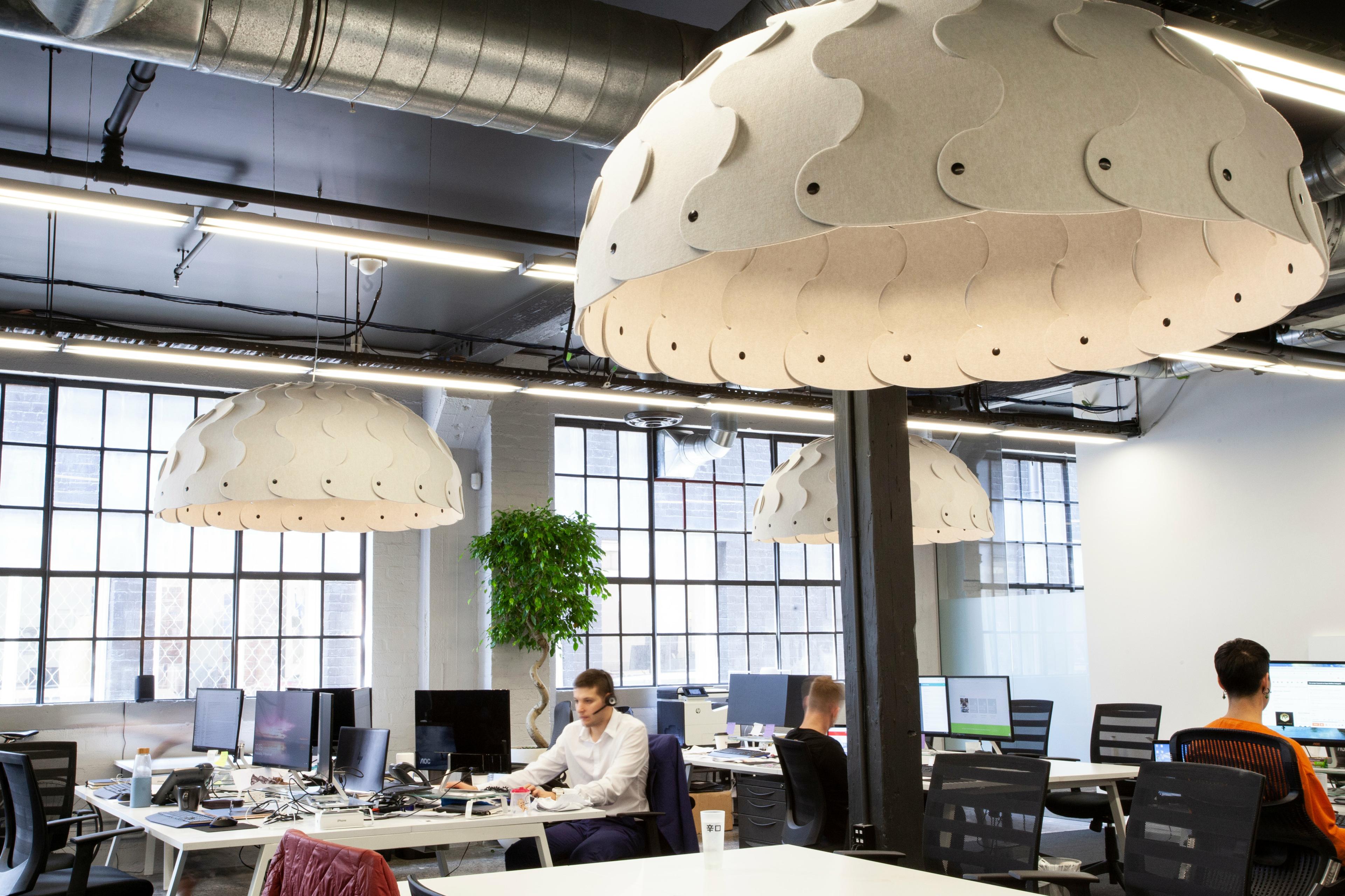 Suspended acoustic office lighting combining functional illumination with sound-absorbing elements for contemporary workplaces