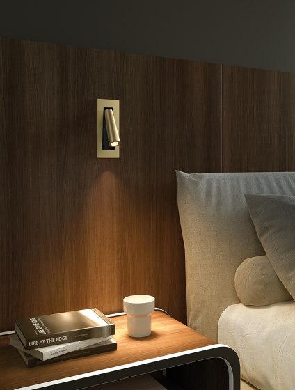 Reading wall lamp installed beside a luxury hotel bed providing comfortable task illumination.