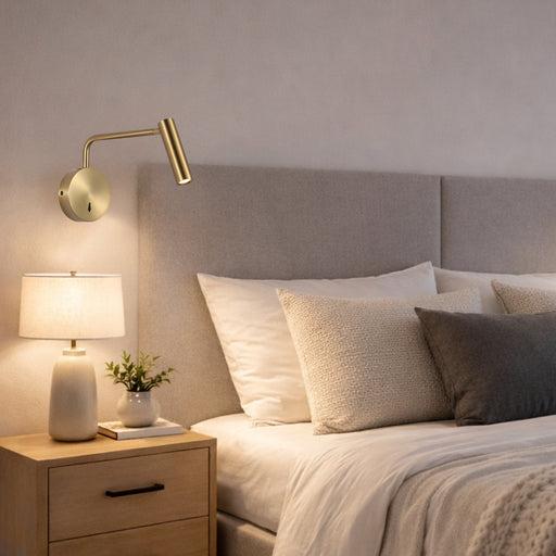 Reading wall lamp installed beside a luxury hotel bed providing comfortable task illumination.