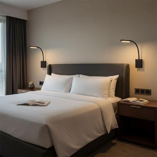 Reading wall lamp installed beside a luxury hotel bed providing comfortable task illumination.
