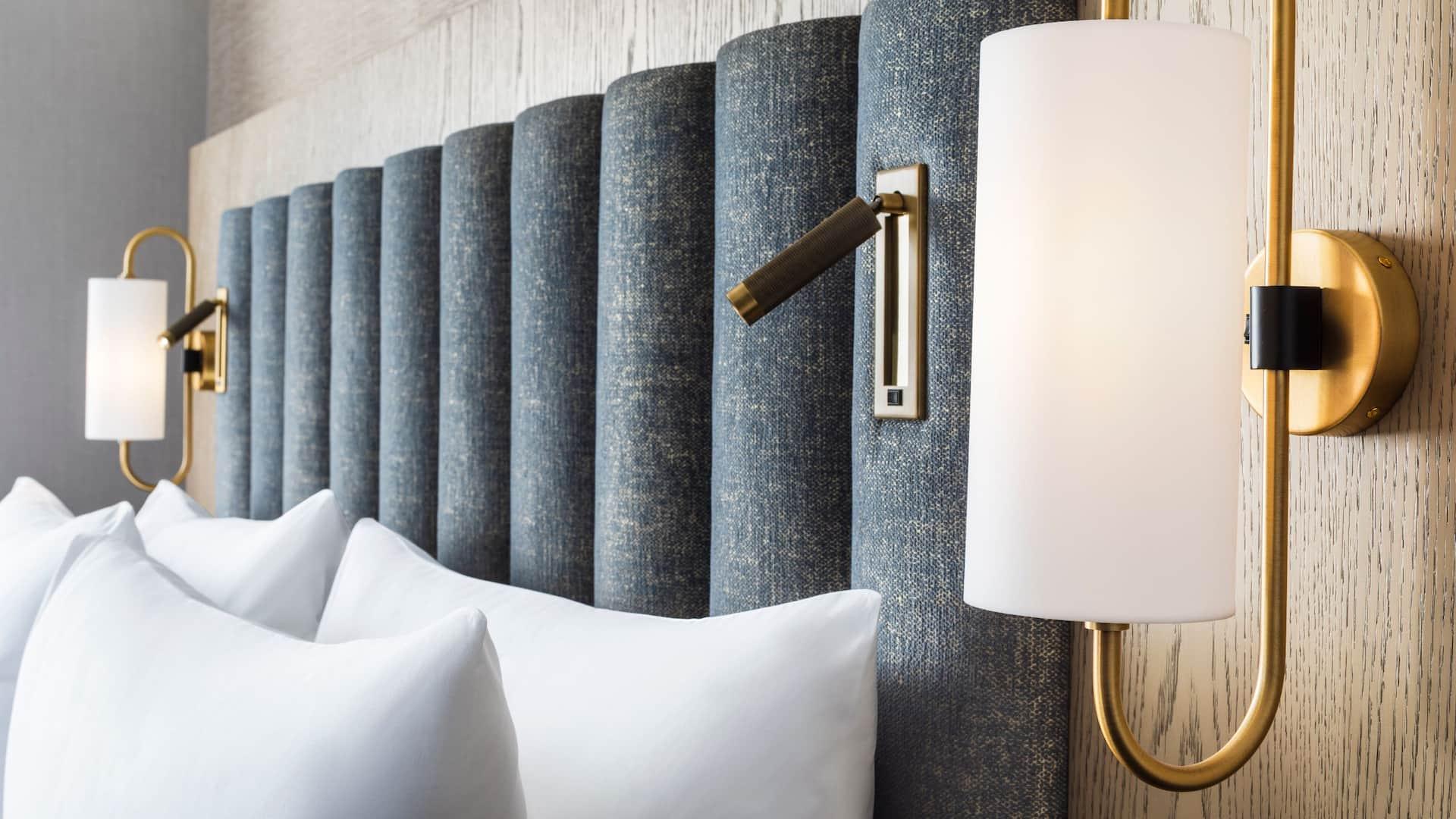 Reading wall lamp installed beside a luxury hotel bed providing comfortable task illumination.