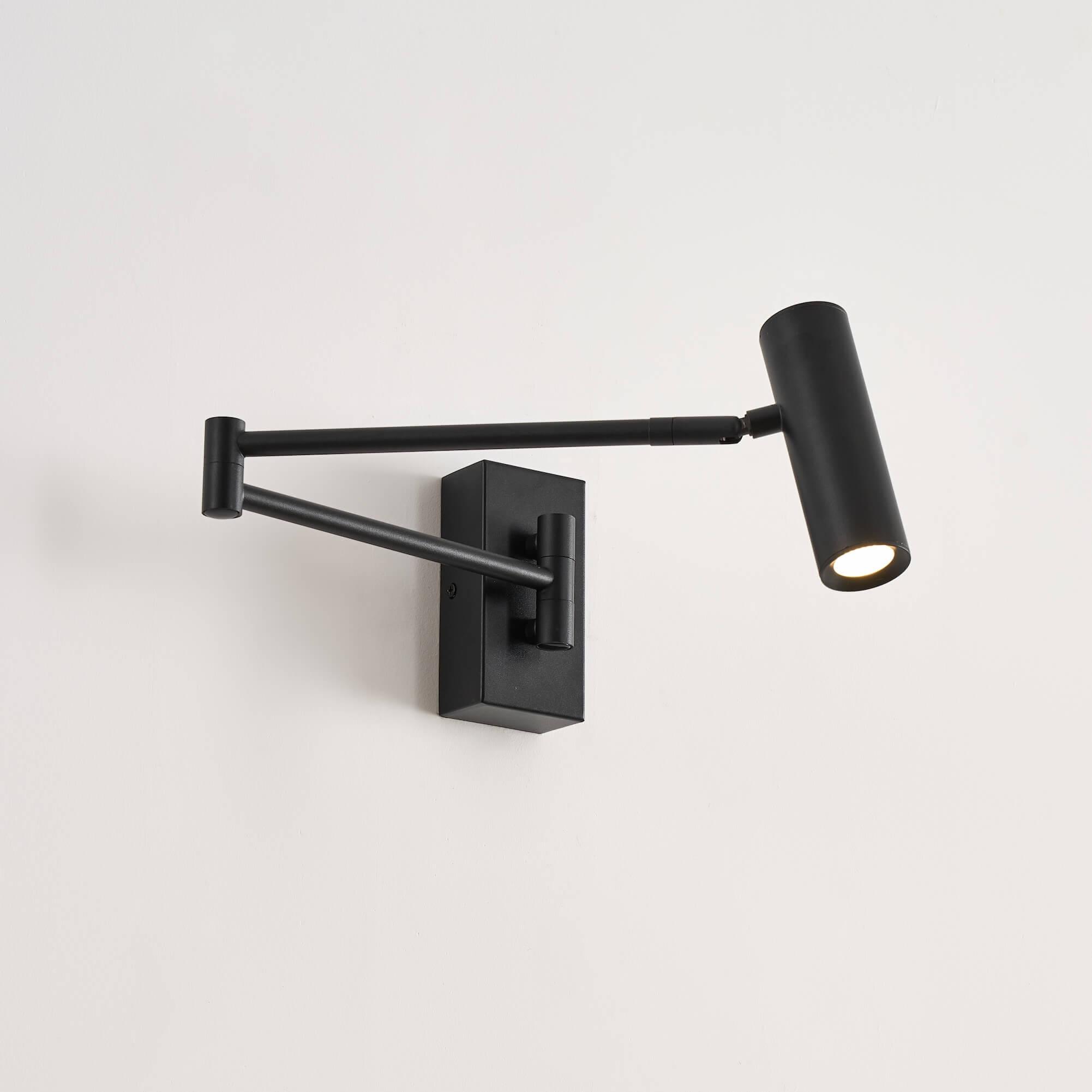 Front view of a reading wall lamp with integrated directional lighting and premium finish.