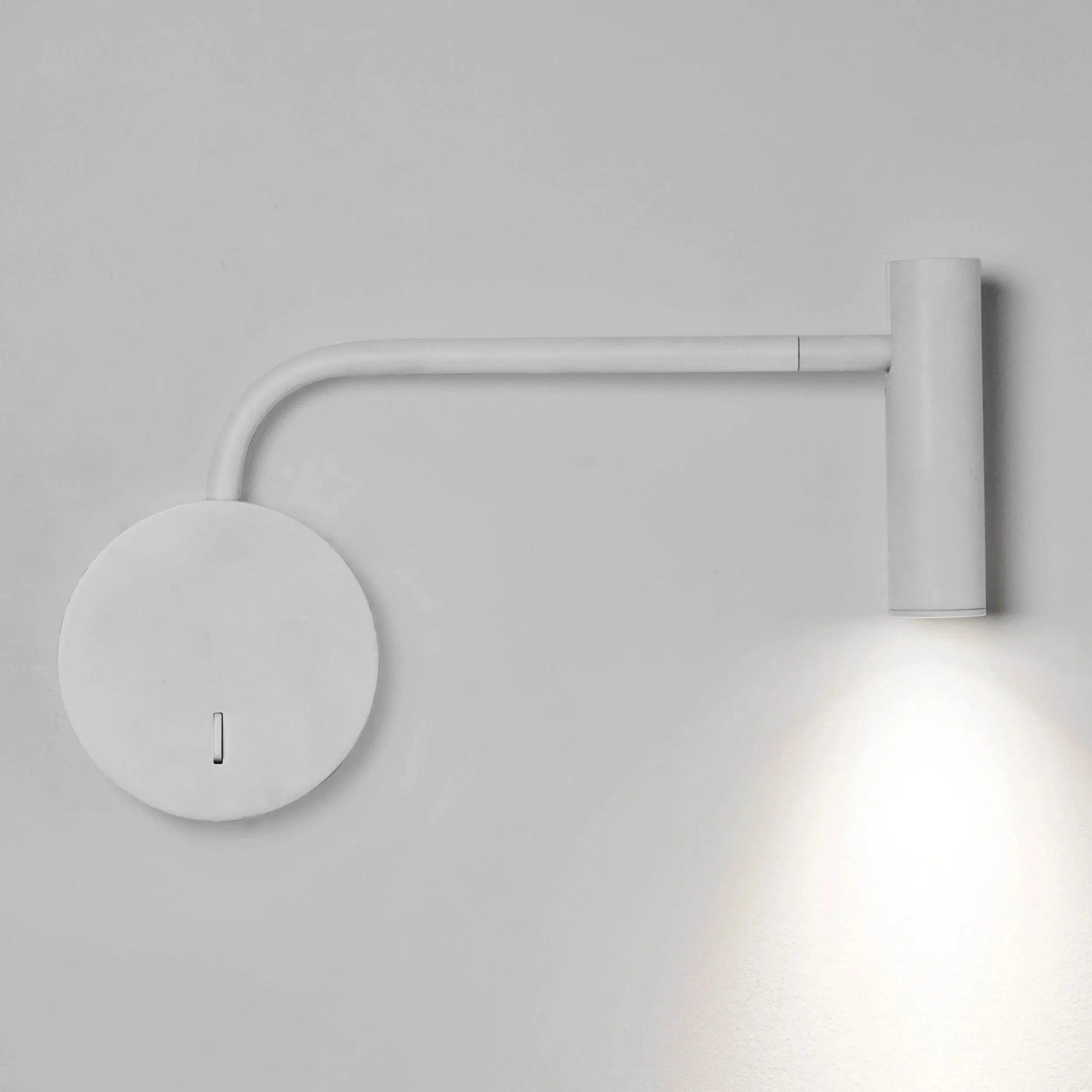 Front view of a reading wall lamp with integrated directional lighting and premium finish.