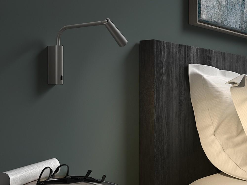 Reading wall lamp installed beside a luxury hotel bed providing comfortable task illumination.